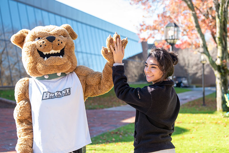 Tupper, Bryant University's mascot, hi-fives a student