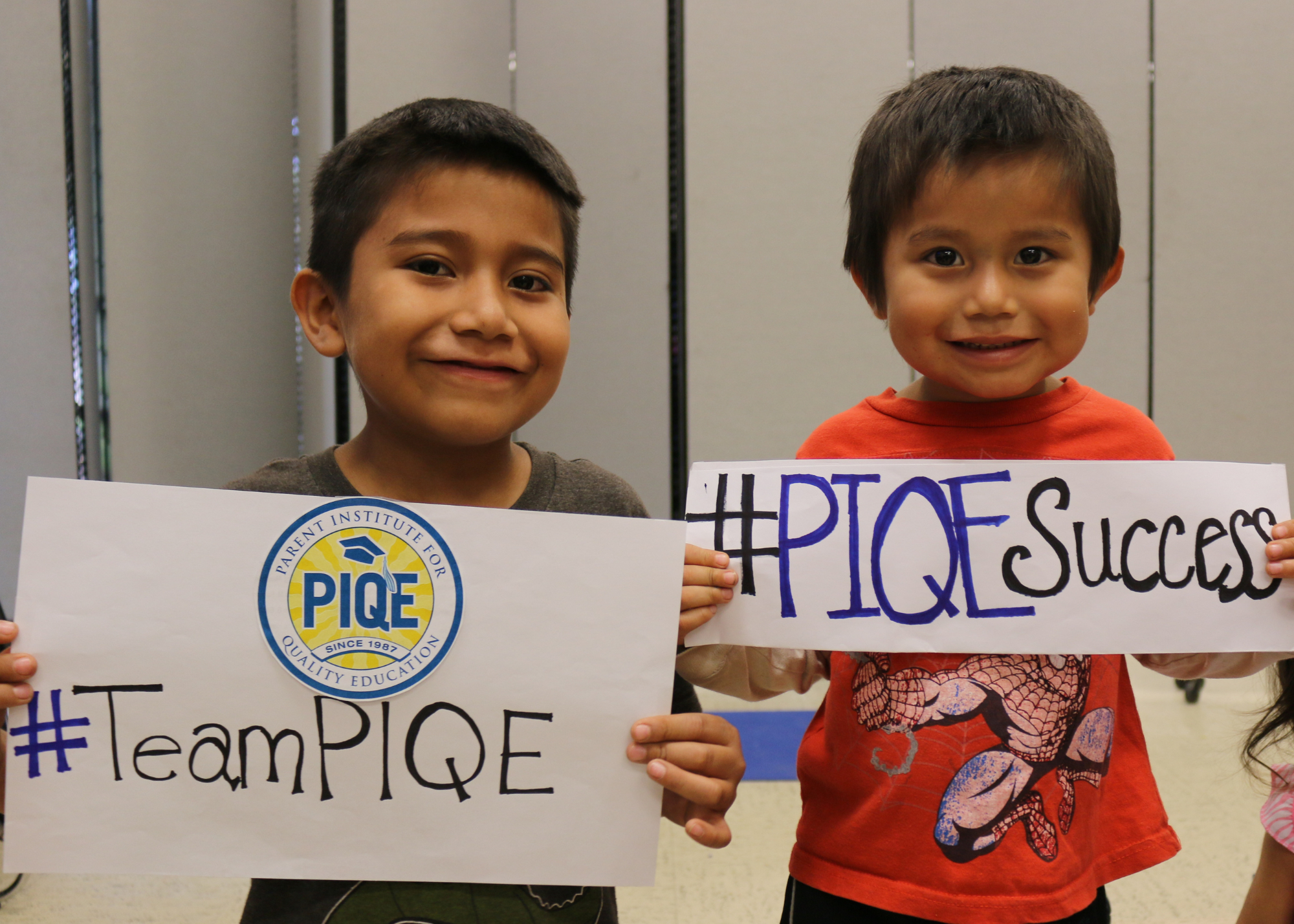 Boys holding PIQE sign